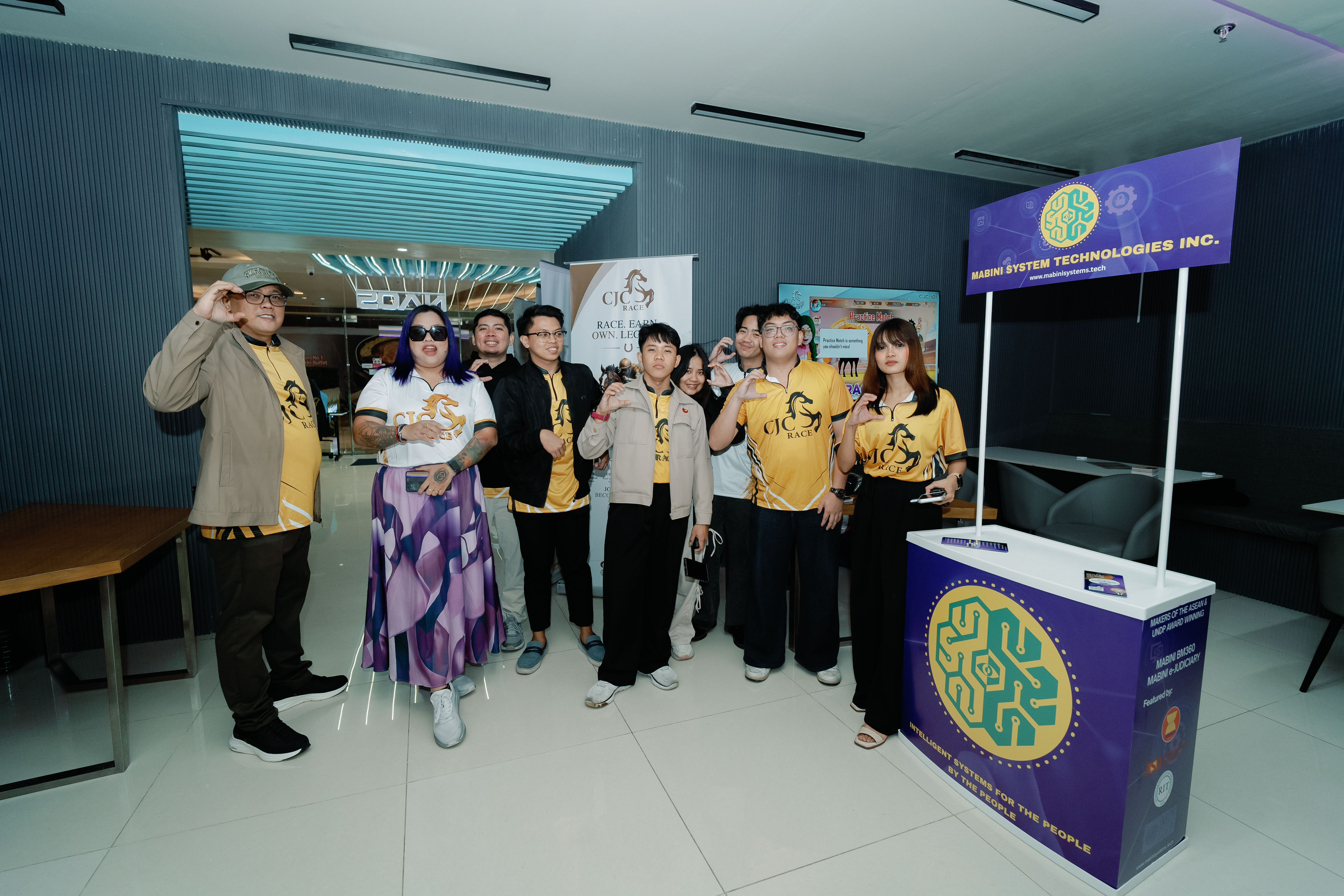 Group photo of the media team and event partners at a branded event booth