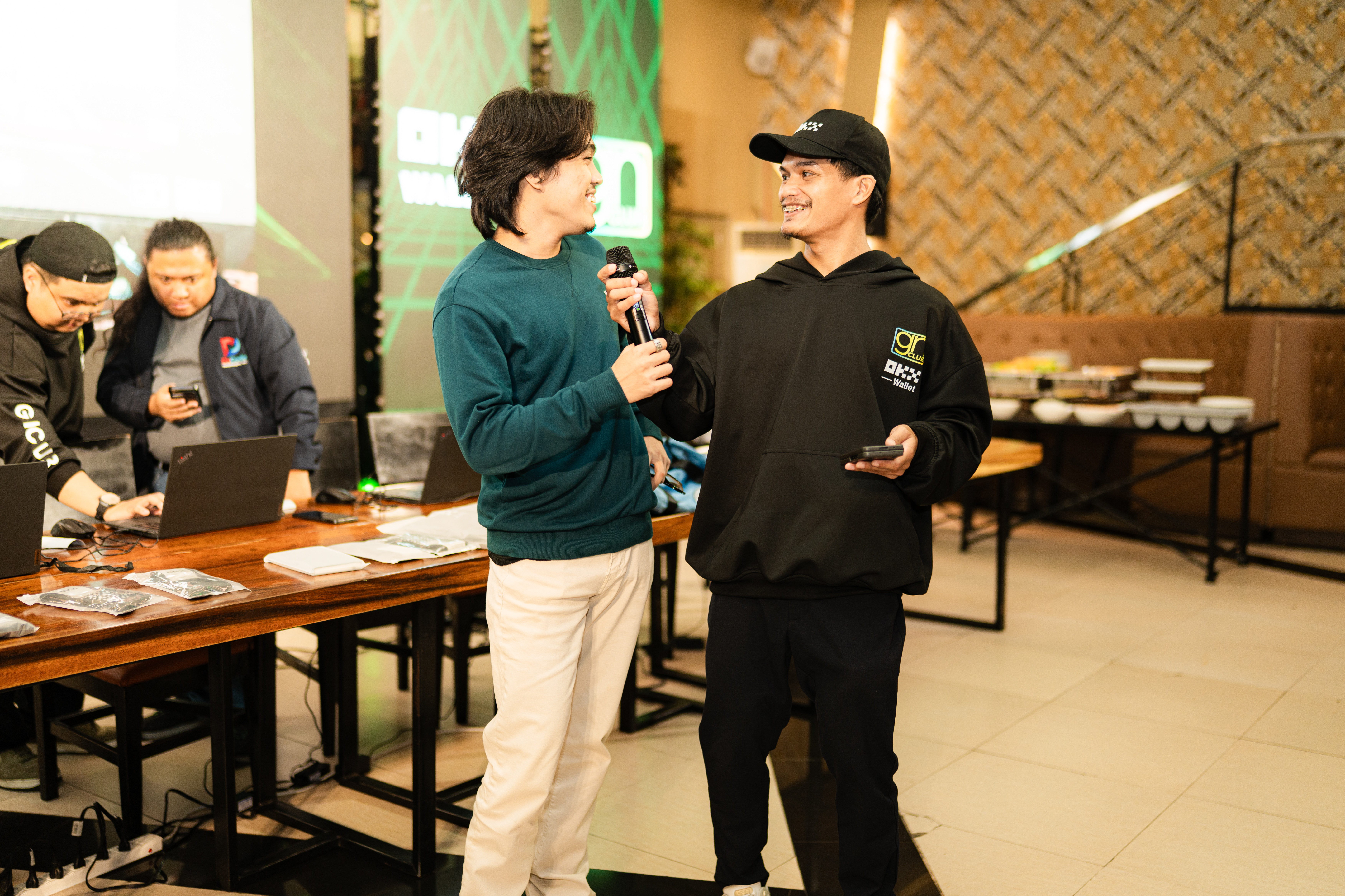 Two people sharing a microphone during a recorded interview segment at an event