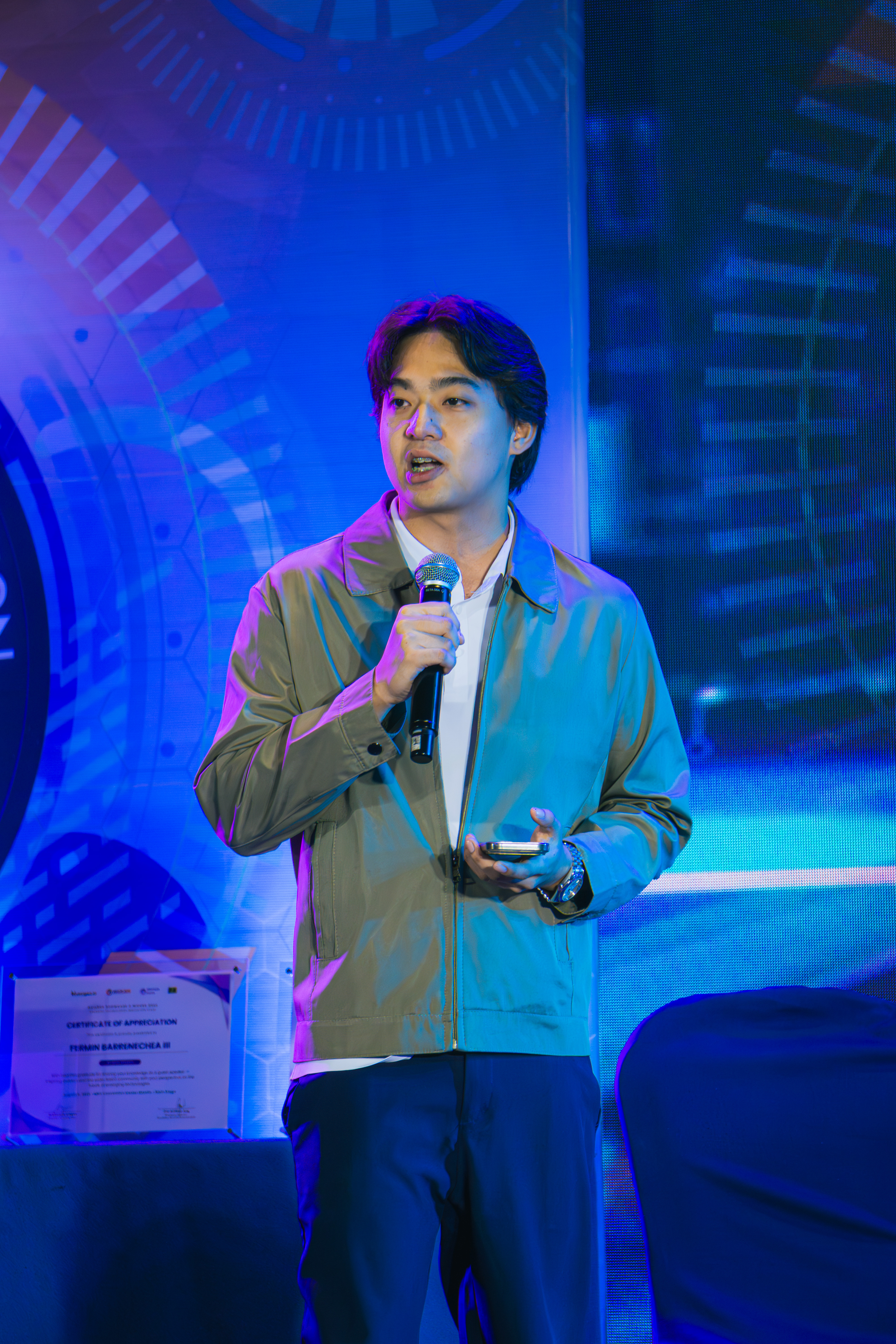 Host wearing a headset microphone speaking at a branded event booth
