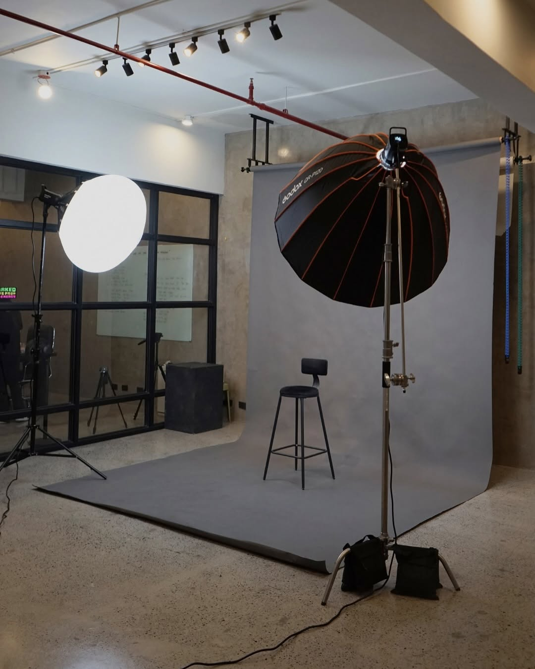 Photography studio bay with a softbox light stand and grey backdrop